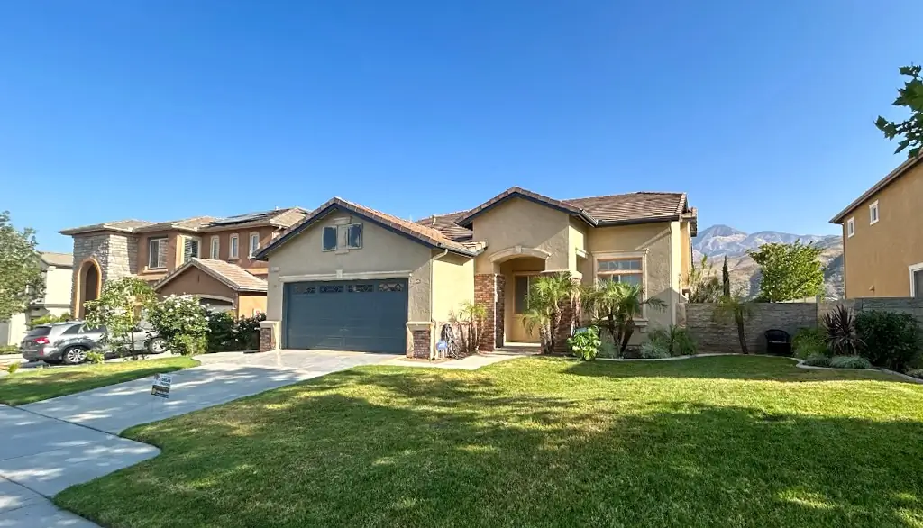 Highland CA home before exterior painting with faded yellow stucco and outdated blue garage door