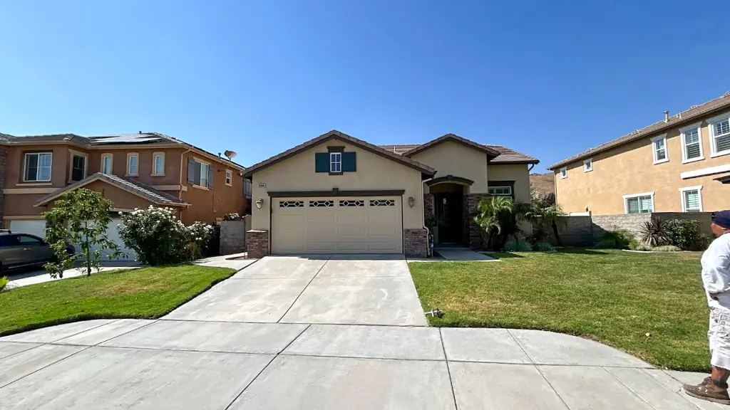 Exterior painting Highland CA completed with warm neutral stucco and modern green shutters