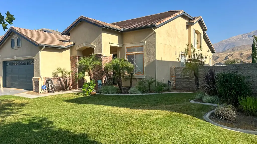 Spanish-style stucco home in Highland CA before exterior painting showing sun-faded yellow walls