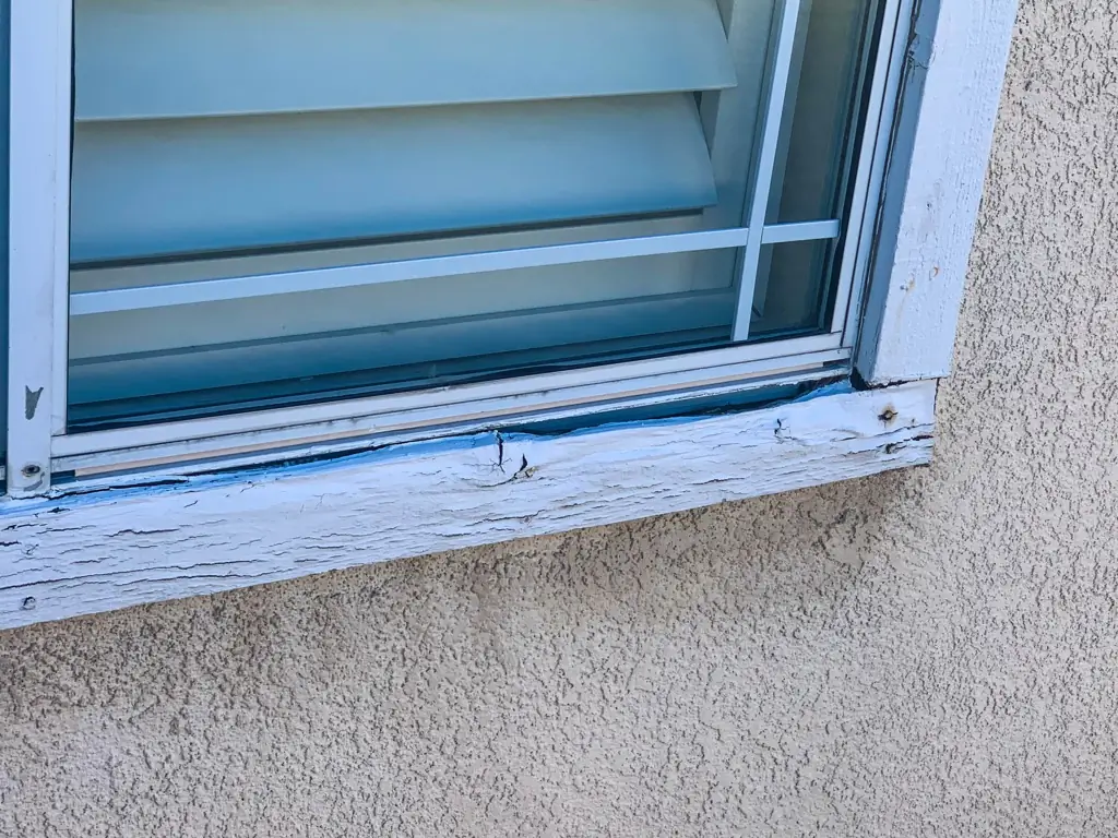 Peeling paint and rot on exterior window frame needing repair in Rancho Cucamonga residence