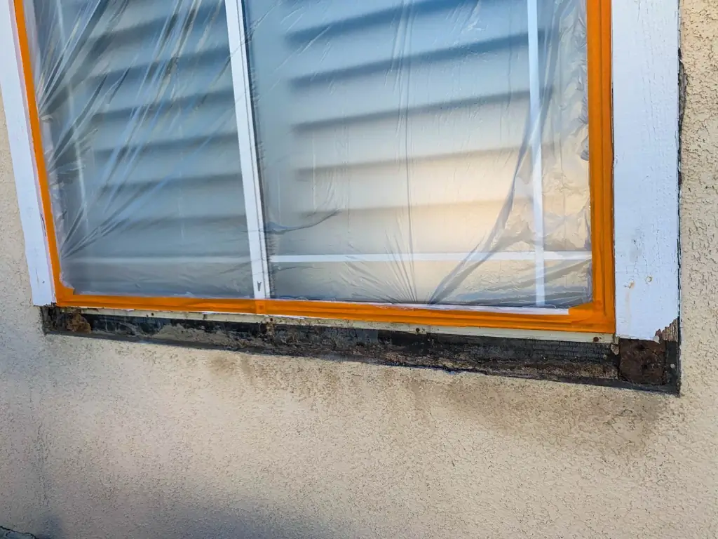 Exterior painting Rancho Cucamonga — window masked and damaged trim removed during surface prep