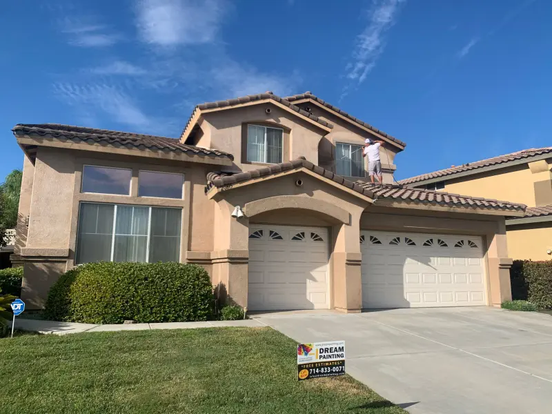 Exterior painting Riverside CA — two-story stucco home with fresh paint on walls, trim, and garage doors