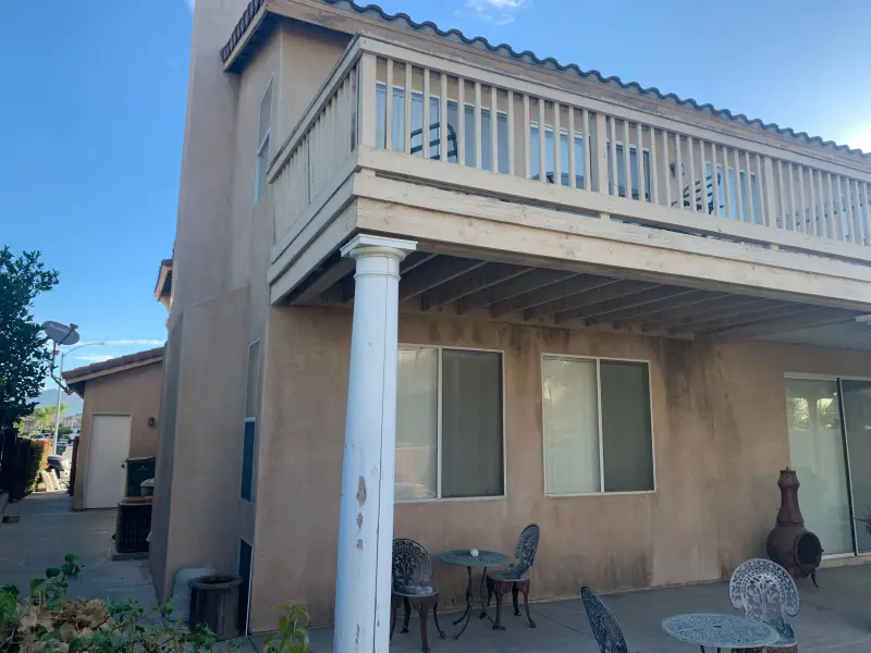 Stucco home painting Riverside — patio columns, balcony underside, and walls with coordinated color scheme
