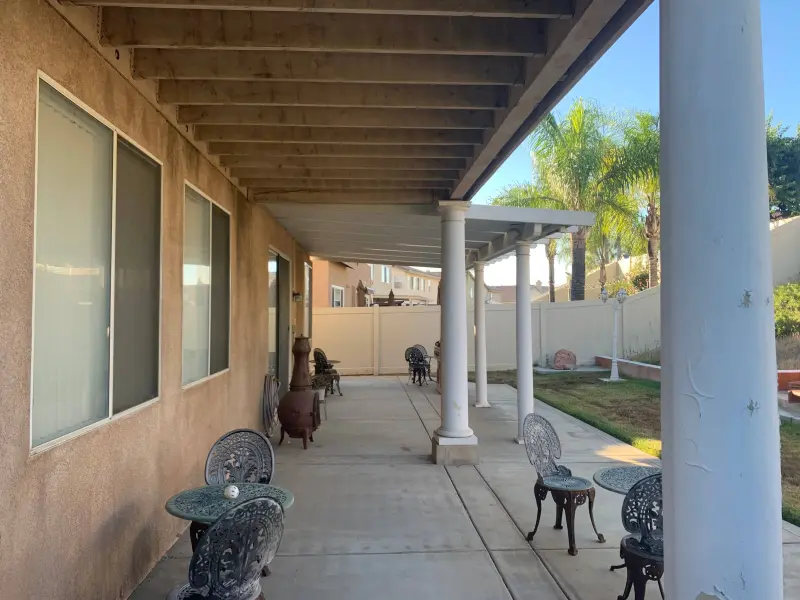 Exterior painting Riverside stucco home — painted patio beams, ceiling, and columns with landscaping