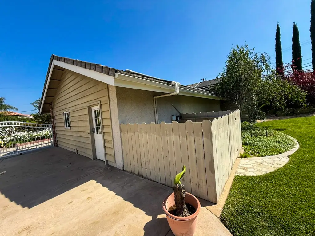Yorba Linda home before exterior painting showing weathered siding and damaged fence
