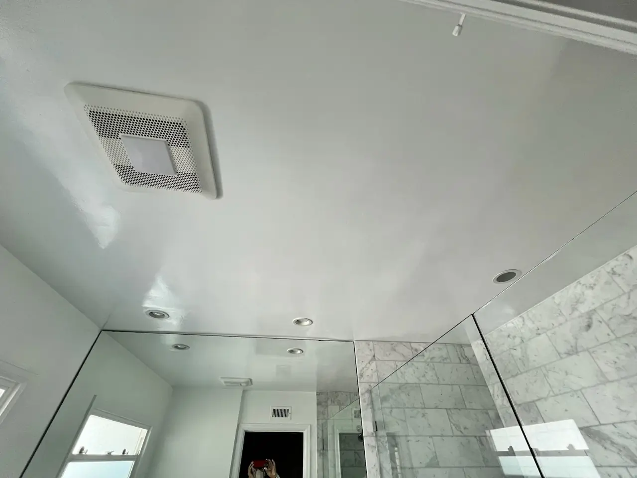 Bathroom ceiling in Costa Mesa after renovation, featuring a smooth, freshly painted surface with integrated lighting and ventilation fixtures.